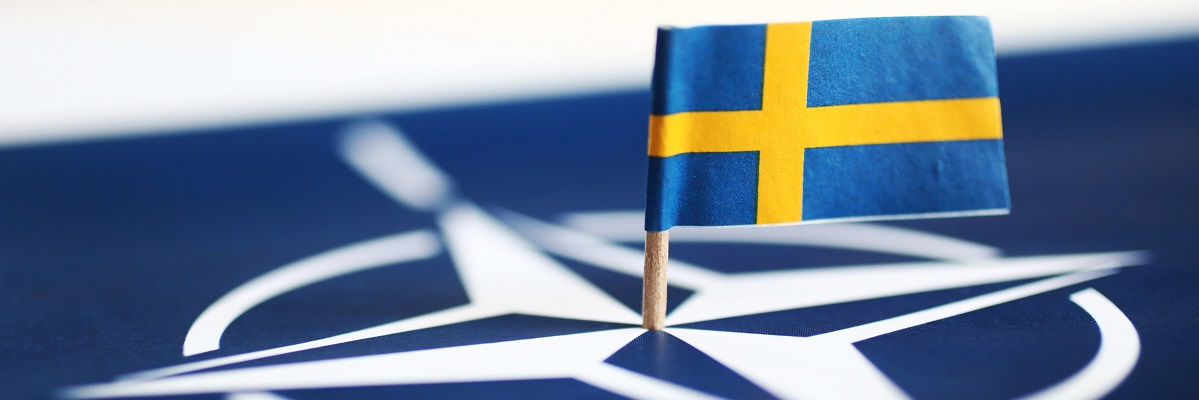 MOTALA, SWEDEN- MAY 17, 2022: The Swedish flag and the NATO symbol.					