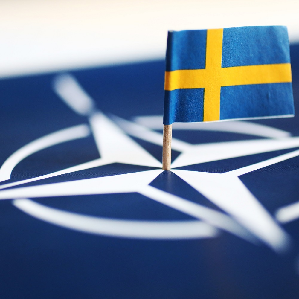MOTALA, SWEDEN- MAY 17, 2022: The Swedish flag and the NATO symbol.					