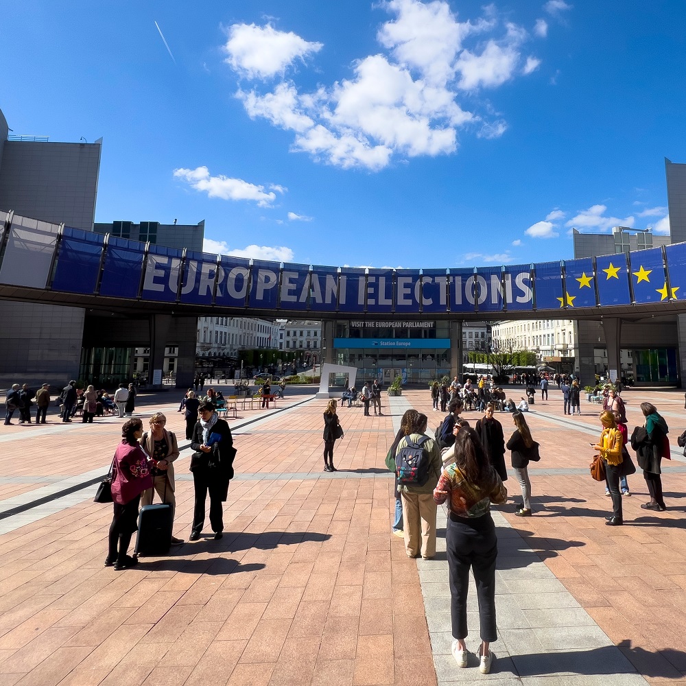 People walk towards a banner promoting the European elections in front of the European Parliament in Brussels, Belgium, 10 April 2024.					
