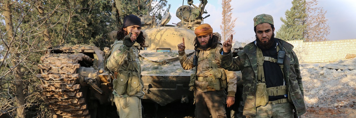 Fighters standing over a destroyed tank