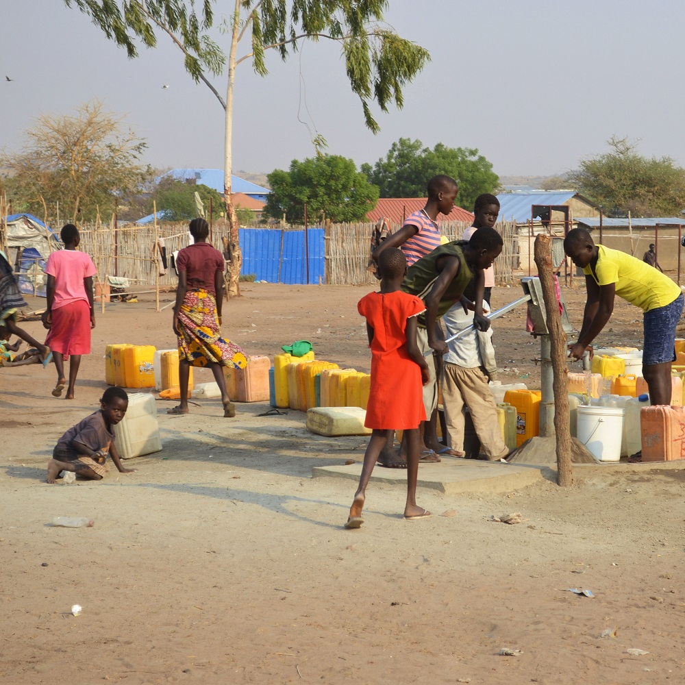 Juba, South Sudan, February 2017. People with yellow jerrycans waiting for water at a borehole site. Salesian camp for internally displaced persons (IDPs).