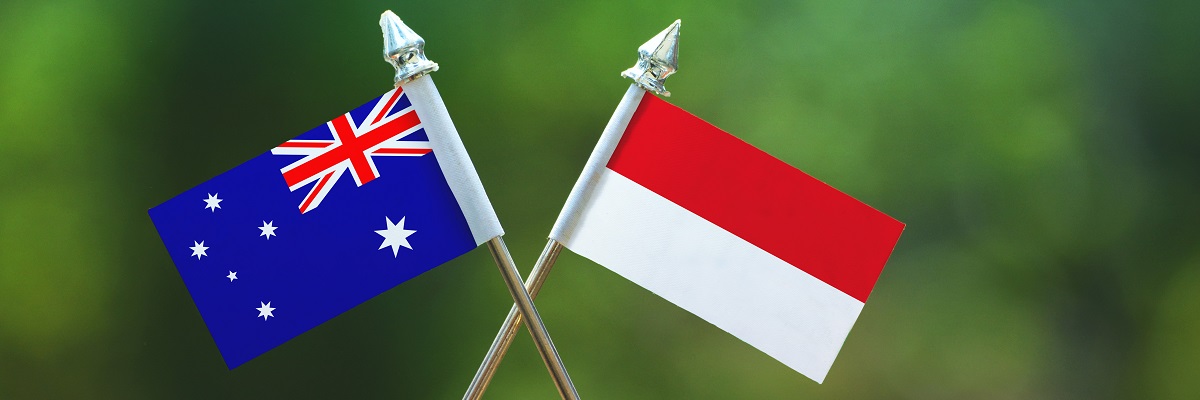 Pequeña bandera de Indonesia y Australia con fondo verde borroso