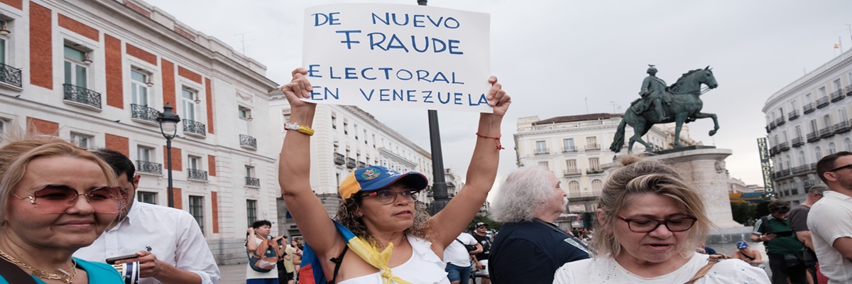 Mehrere Personen während der Demonstration gegen die Ergebnisse der venezolanischen Wahlen bei Sonnenuntergang am 29. Juli 2024 in Madrid, Spanien