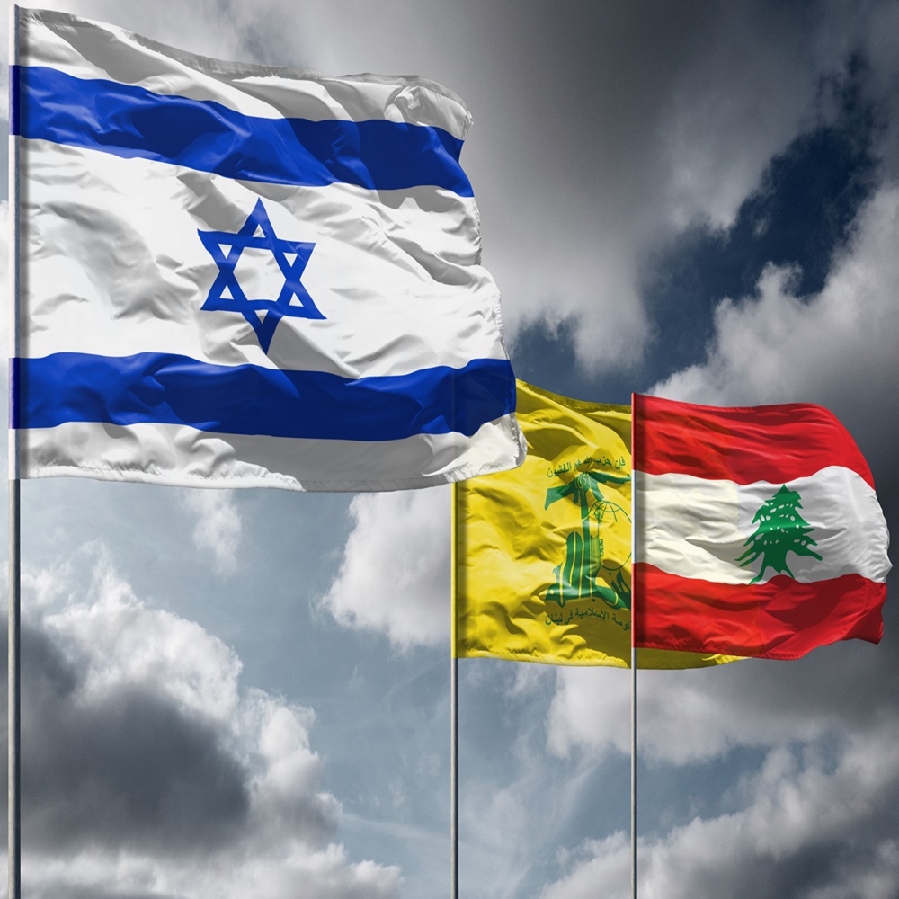 Flags of Israel above dark sky. Hezbollah and Lebanon flags in background