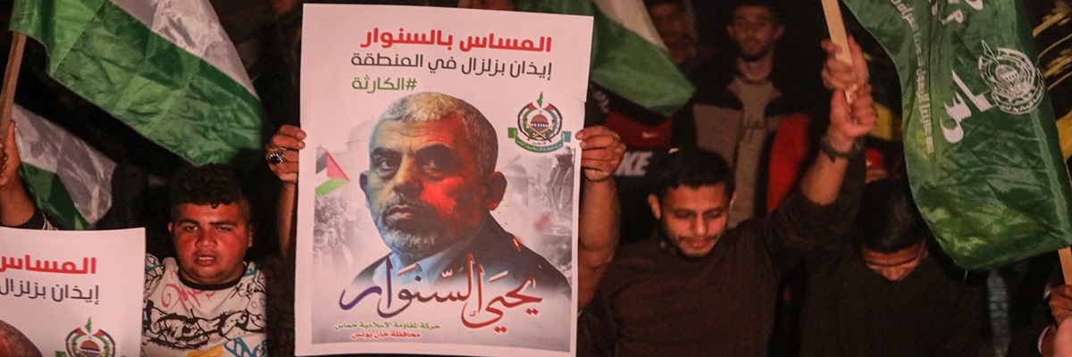 Palestinian supporters of Hamas stand in front of the house of their leader, Yahya Sinwar, in solidarity with him after Israeli threats to kill him, in Khan Yunis in southern Gaza Strip on May 6, 2022