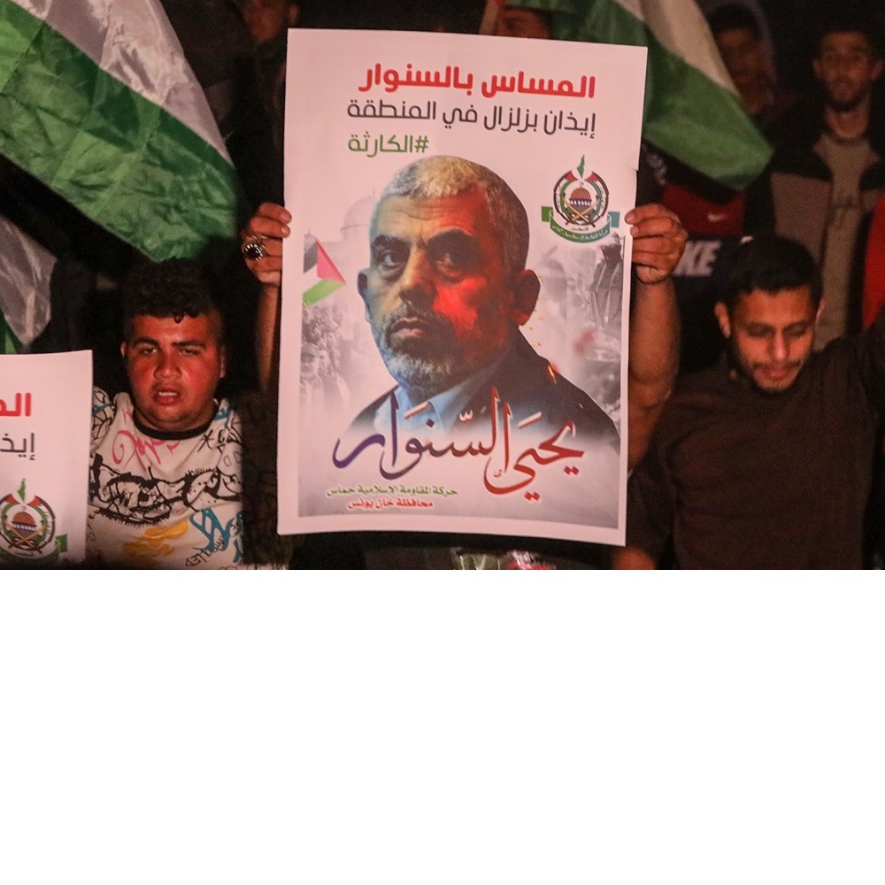 Palestinian supporters of Hamas stand in front of the house of their leader, Yahya Sinwar, in solidarity with him after Israeli threats to kill him, in Khan Yunis in southern Gaza Strip on May 6, 2022