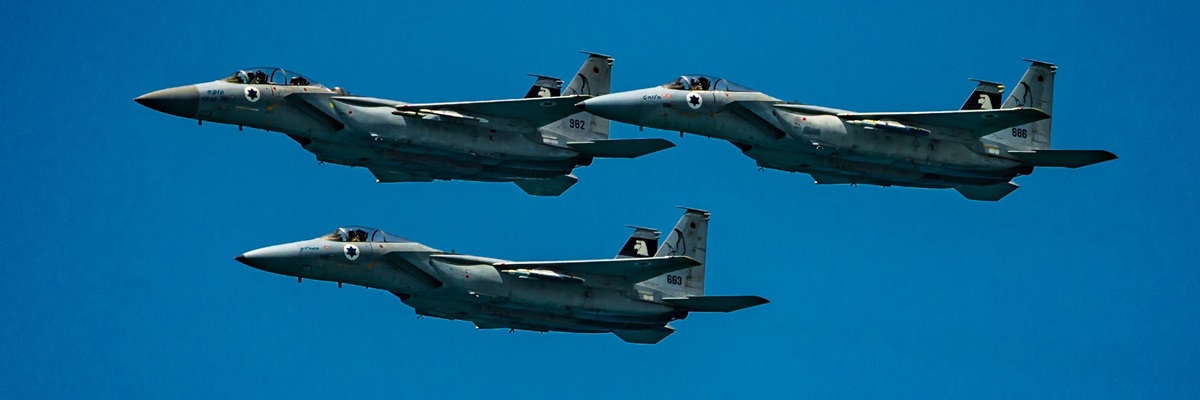 TEL AVIV, IL - May 05, 2022: Three fighter jets flying in formation in front of a stunning beach in Tel Aviv, Israel