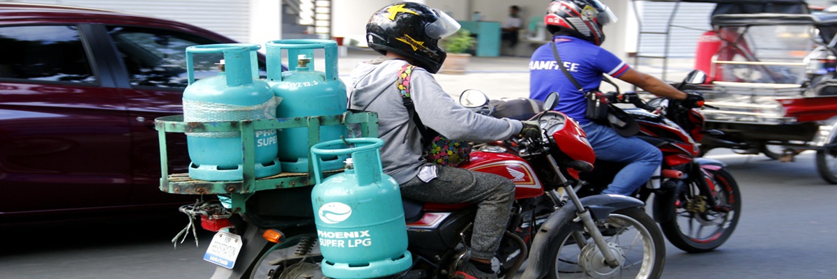 Antipolo City, Philippines - June 1, 2020: RIder use motorcycle to deliver multiple tanks of LPG or liquified petroleum gas to a customer..