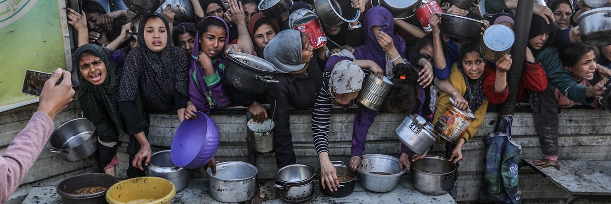 People gather to receive meals from the Rafah charitable kitchen (Tekka) as Palestinians face famine, in Khan Yunis, in the southern Gaza Strip, on January 2, 2025.