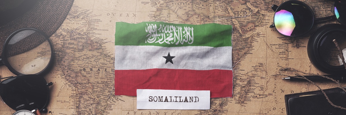 Somaliland Flag Between Traveler's Accessories on Old Vintage Map. Overhead Shot