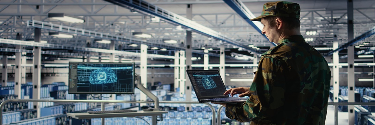 Soldier in engineering role uses AI application on laptop to manage server hub systems. Army commander reviews secret intelligence information using artificial intelligence in data center, camera A