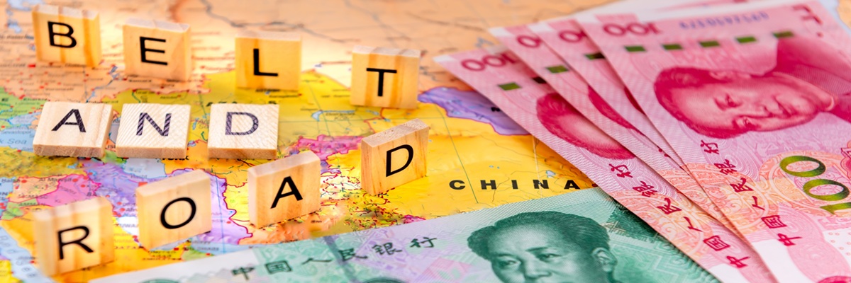 A Belt And Road Initiative concept with letter tiles and Chinese Yuan bank notes on a map of China.